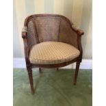 Early 20th century caned beech bergère chair, of tub form, raised on stop-fluted tapered legs