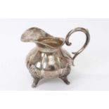 Late 19th century white metal cream jug of compressed baluster form,
