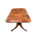 Regency mahogany twin pedestal dining table, with rounded rectangular reeded top, on turned pedestal
