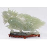 Large Chinese jade or green hardstone carving of a mythical beast, raised on wooden plinth, 43cm lon