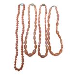Four Chinese carnelian bead necklaces with silver clasps, 64cm - 52cm long