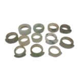 Collection of twelve Chinese polished green hard stone/ jade rings