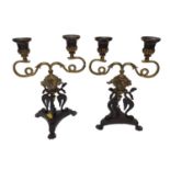 Pair of antique two-branch bronze candlesticks, with serpent decoration, on lion paw feet, 25cm high