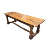 17th century style oak refectory table, the plank top with cleated ends, with boss carved frieze on