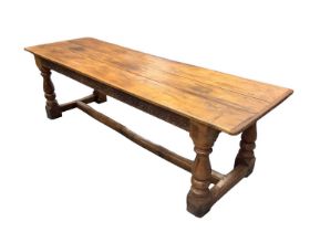 17th century style oak refectory table, the plank top with cleated ends, with boss carved frieze on