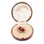 Regency gold enamel and pearl brooch with a central half pearl on red guilloché enamel ground surrou