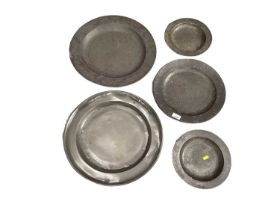 Two large early pewter chargers together with three other pewter plates