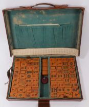 Old mahjong set in brown leather case together with a set of mahjong red lacquered counter stands