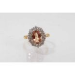 Imperial topaz and diamond cluster ring with an oval cut imperial topaz surrounded ten brilliant cut