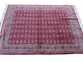 Part silk Bokhara style rug, having eight rows of eighteen quartered medallions in geometric borders