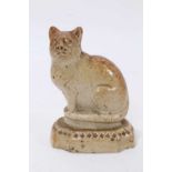 A Victorian salt-glazed stoneware model of a cat, seated on a cushion base, 7.5cm high