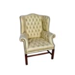 Georgian leather upholstered wing armchair, raised on square supports