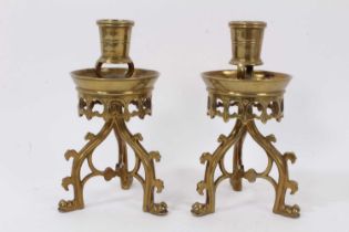 A pair of Gothic Revival brass candlesticks