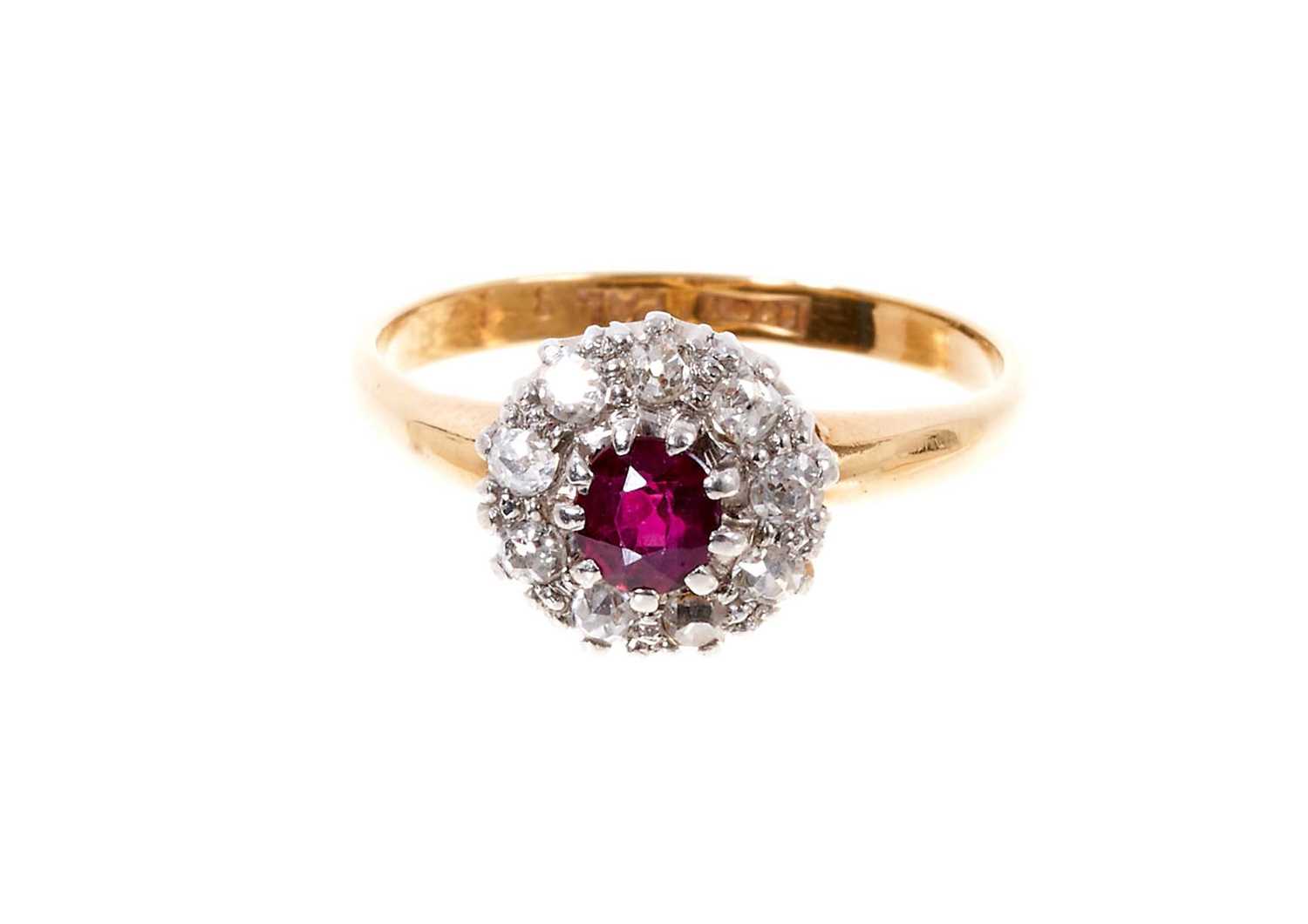 Antique ruby and diamond cluster ring with a central mixed cut ruby surrounded by nine old cut diamo
