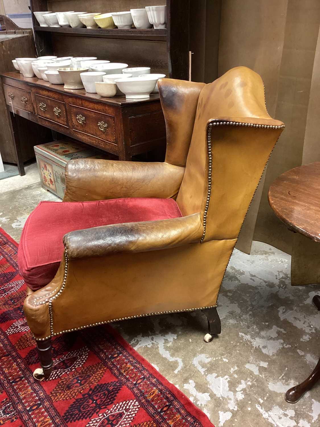 Early 19th century leather upholstered wing armchair, raised on ring turned legs and castors - Image 13 of 13