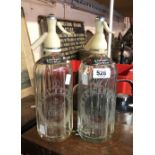 A pair of vintage Schweppes soda syphons with acid etched and paper labels