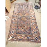 A Turkish hand made wool rug with central repeat motifs within a triple border - wear - 2.2m X 1.