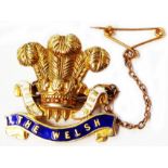 A marked 9ct and enamelled insignia brooch for The Welsh Regiment, with safety chain