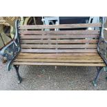 A two seater cast iron garden bench with wooden slatted seat - sold with a pair of matching single