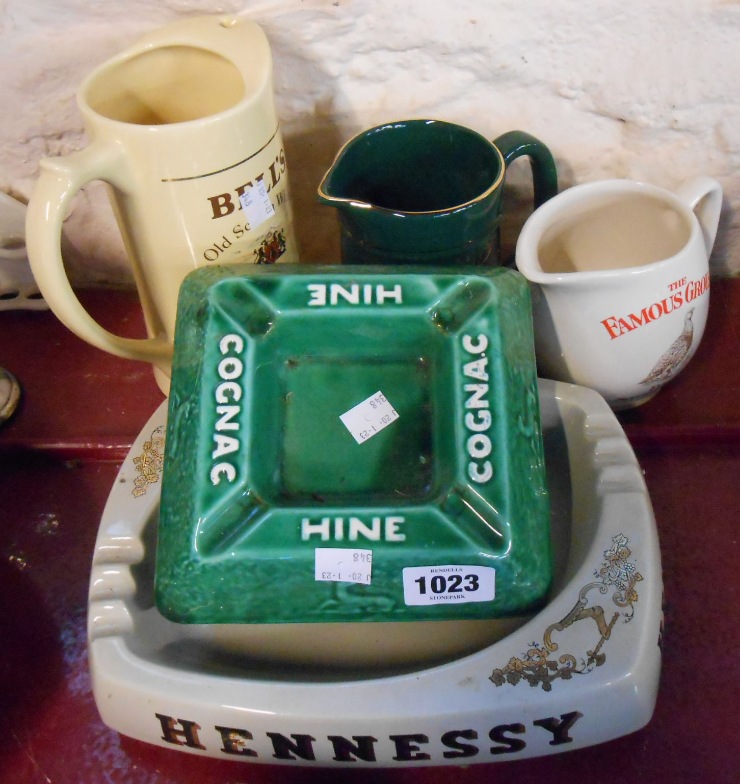 A small selection of pub related ceramics comprising whisky jugs and ashtrays