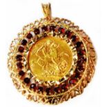 A 1915 gold Sovereign, loose mounted in an ornate 375 (9ct.) gold garnet set pendant with pierced