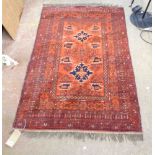 A North Indian hand made wood rug with central motifs within a triple border on red ground - applied