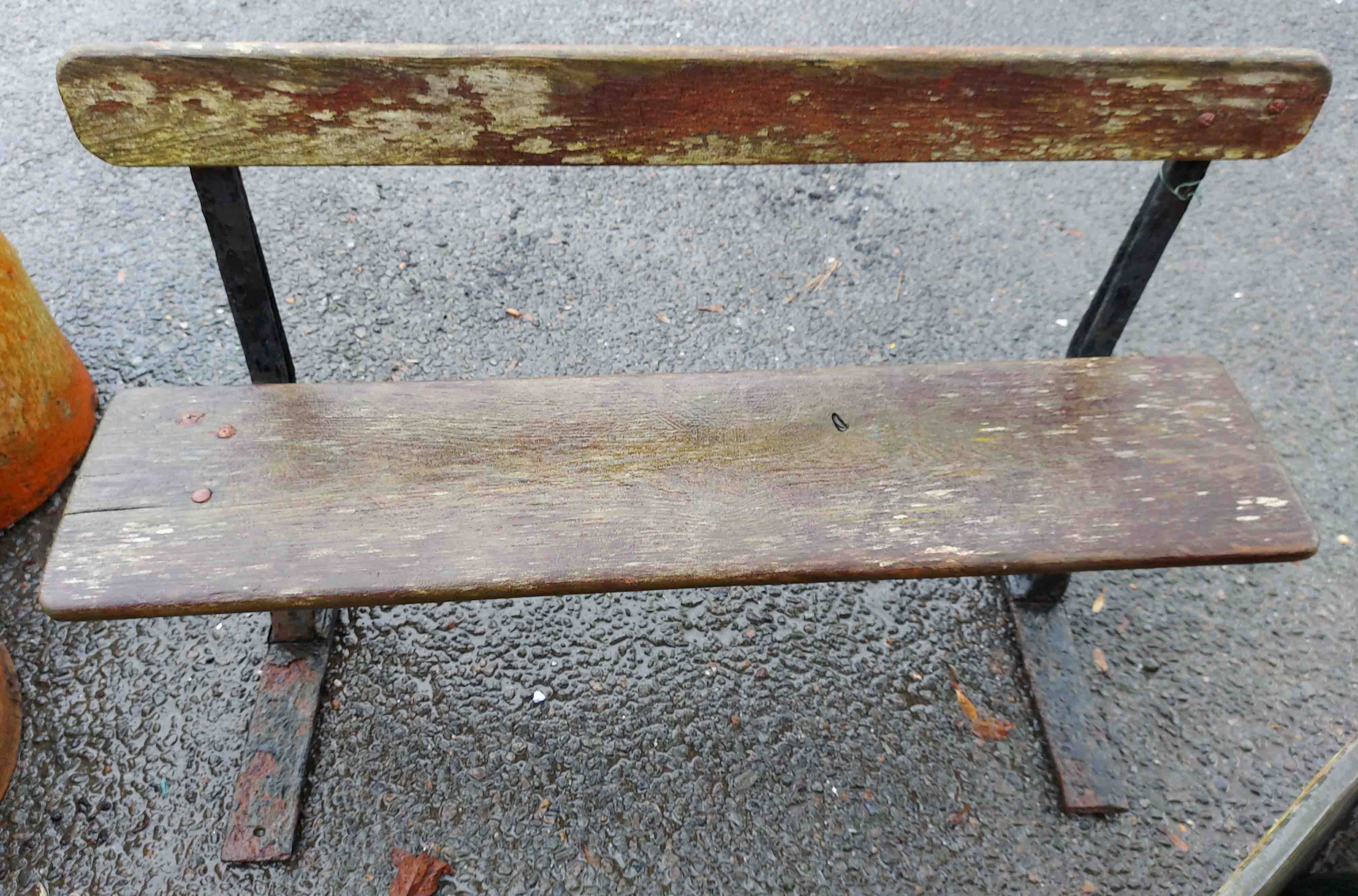 An old cast iron folding bench with woo An old cast iron folding bench with wooden slat back and