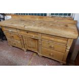 A 1.82m antique stripped pine dresser base with thick two plank top, three blind frieze drawers,