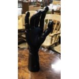 An old articulated artist's model hand with black painted finish