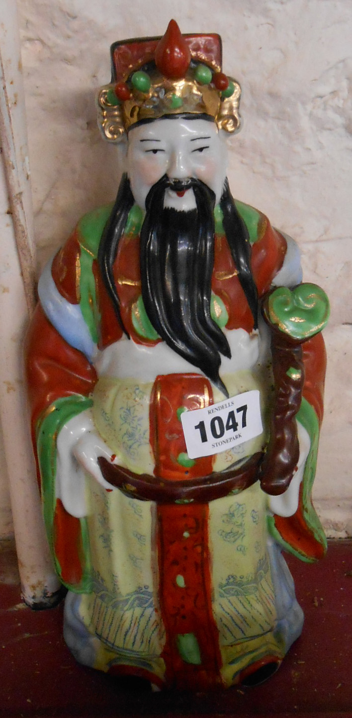A 20th Century Chinese porcelain figurine depicting a scholar with hand painted decoration