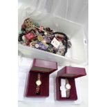 A plastic crate containing buttons, costume jewellery and two boxed Constant modern ladies' quartz