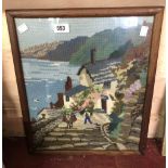 An old embroidered picture depicting a view of Clovelly, North Devon set in oak frame