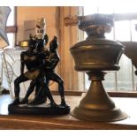 A vintage plaster table lamp depicting African dancers - sold with a brass oil lamp