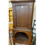 A 90cm antique stained oak freestanding corner cabinet with remains of dentil cornice and