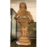 An Art Deco plaster figure depicting a young girl in cute pose with terracotta effect paint finish -