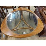A 76cm retro teak effect and glass topped triangular coffee table, set on triple supports with