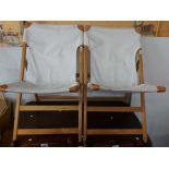 A pair of Ikea wood framed folding lounge chairs with slung fabric upholstery