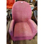 A 1930's cottage armchair with curved back and original upholstery (worn), set on casters
