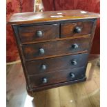 A 32cm antique mahogany miniature chest of two short and three long graduated drawers, set on plinth