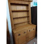 A 1.24m antique pine two part dresser with three shelf open plate rack over a base with two short
