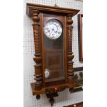 A German stained walnut cased 19th Century style wall clock with visible pendulum and