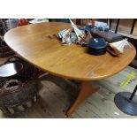 A 1.45m G-Plan teak effect oval extending table with stowed leaf, set on shaped standard ends