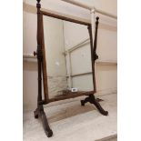 An Edwardian stained walnut framed swing dressing table mirror with flanking candle taper sconces,
