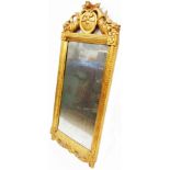 An antique giltwood framed pier mirror with ornate pierced pediment and original oblong plate