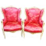 A pair of French cream painted and parcel gilt part show frame armchairs with studded red floral