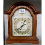 A reproduction polished wood cased break arch topped timepiece with battery movement - sold with a