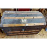 An 81cm late Victorian metal and slatted wood bound dome-top travelling trunk with flanking iron