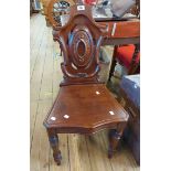 A Victorian mahogany pierced shield back hall chair with moulded solid seat, set on turned front