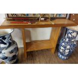A 1.32m blonde and stained hardwood console table with sectional bi-wood top and decorative ends,