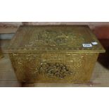 A vintage embossed brass clad log box decorated with scenes of revellery